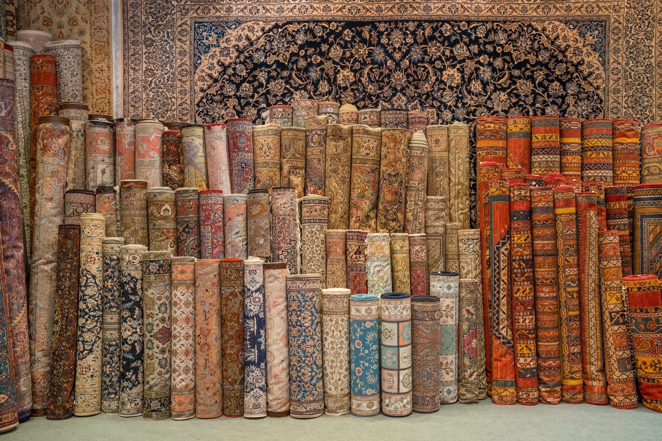 Rolled rugs stored upright against a wall
