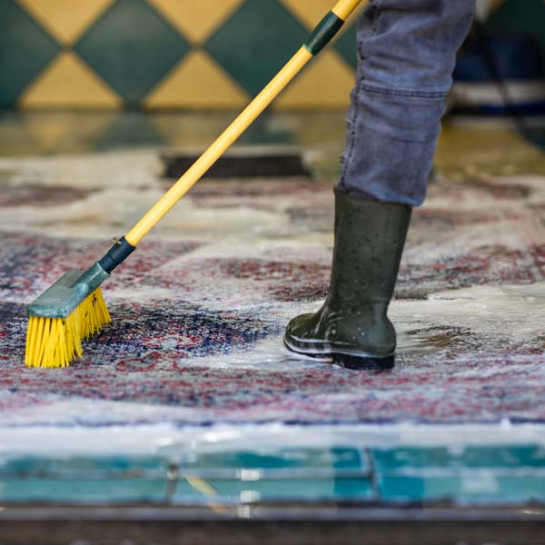 Full-immersion washing at our Yatala facility, scrubbing a soaked rug