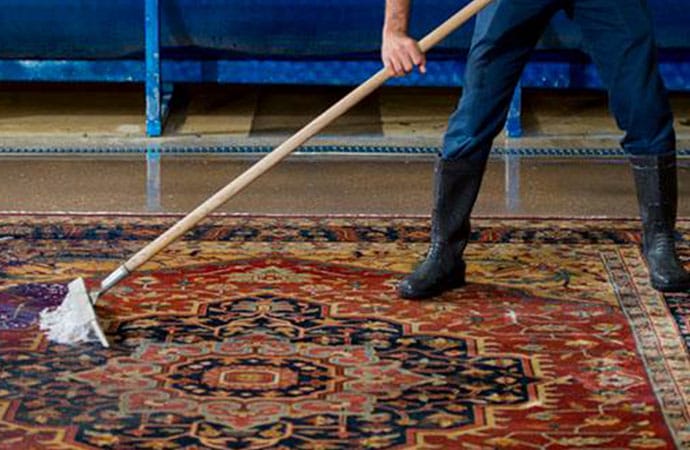 Scrubbing a rug by hand during a full immersion wash
