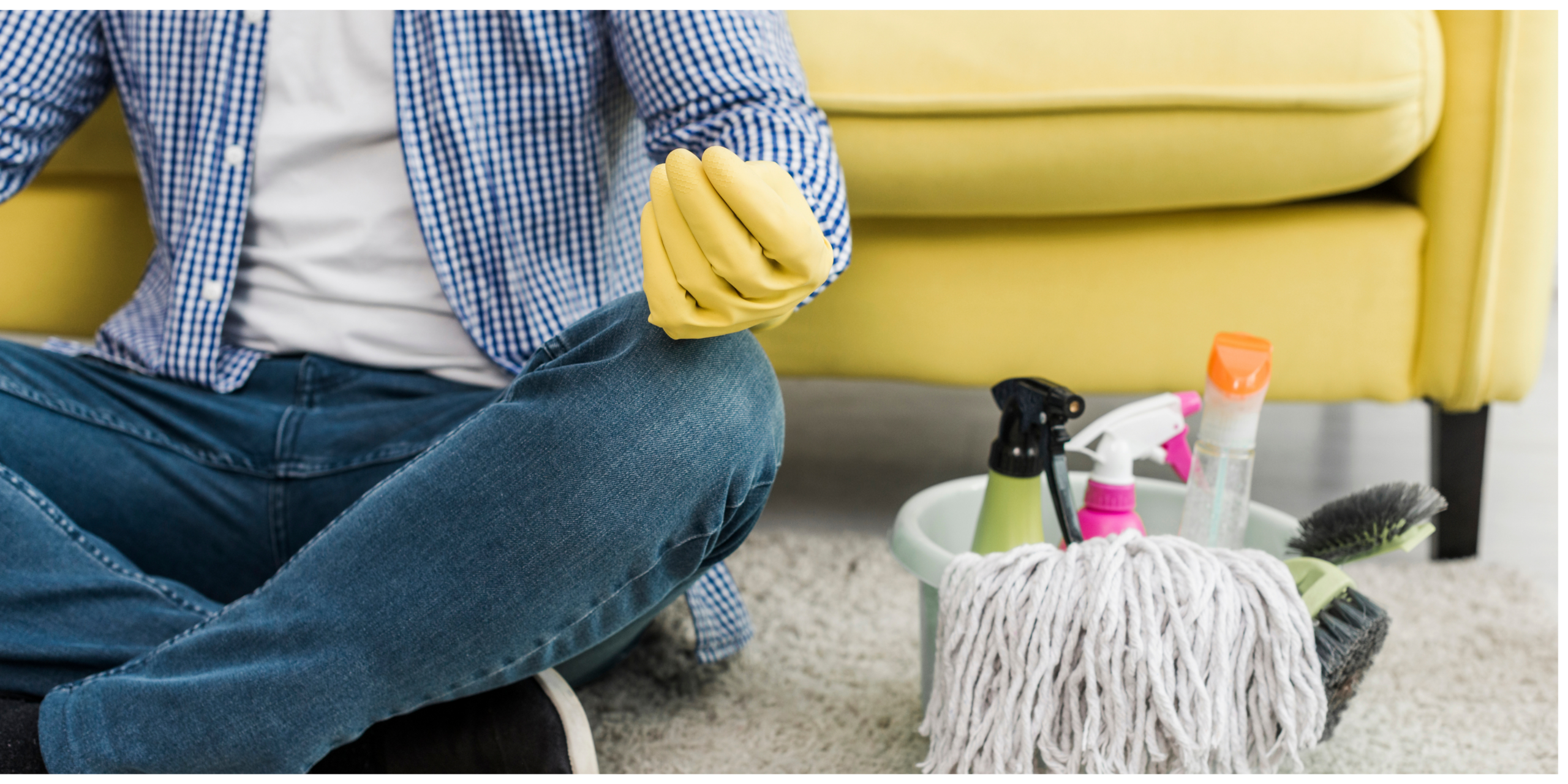 Person kneeling on a carpet beside a bucket of cleaning supplies