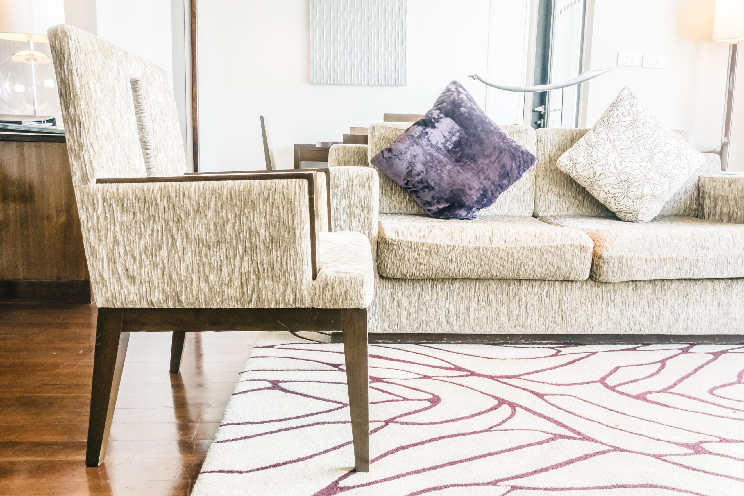 Cream armchair and sofa on a cream and burgundy patterned rug