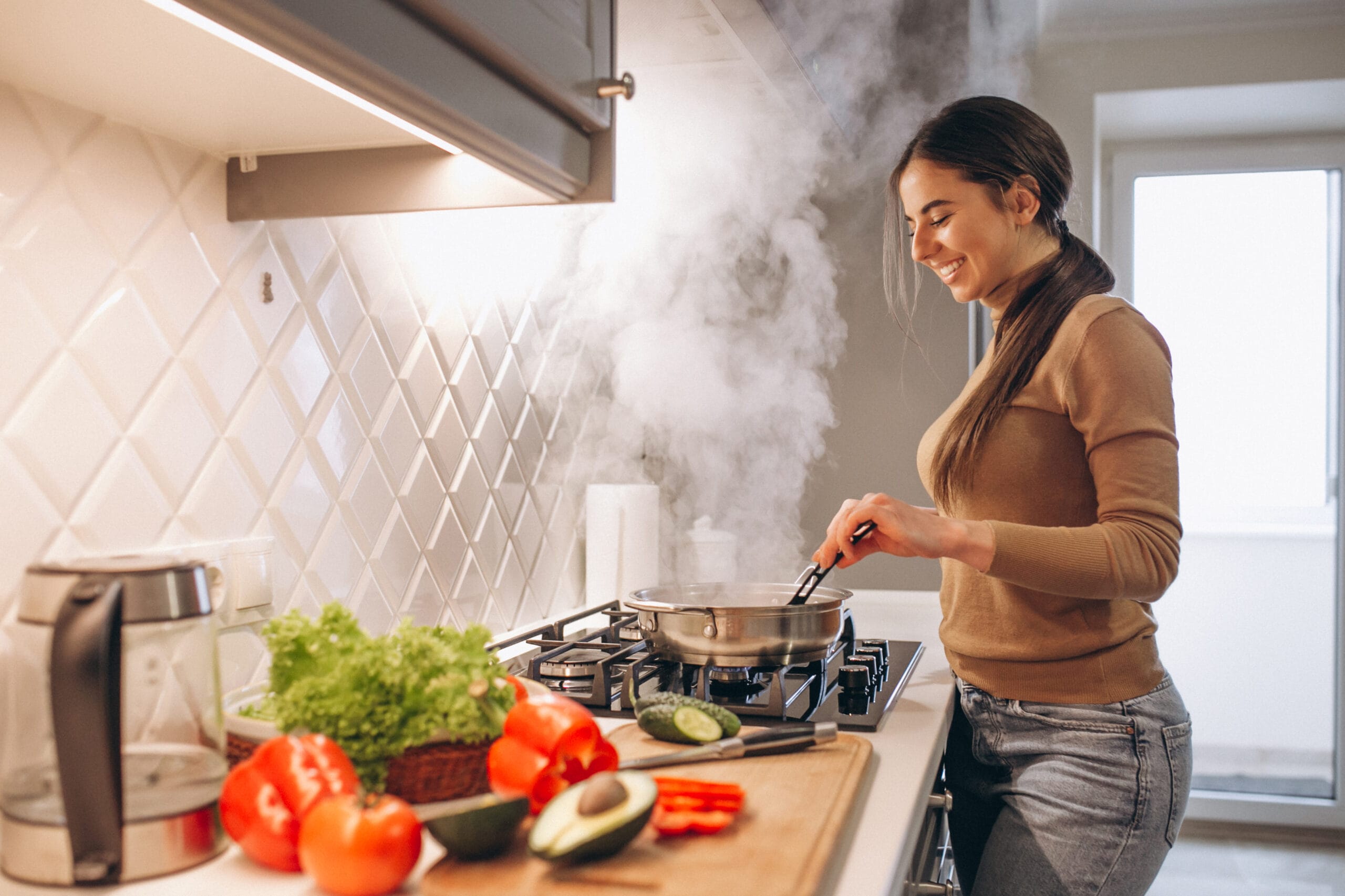 Woman cooking at a stove with steam rising from a pan