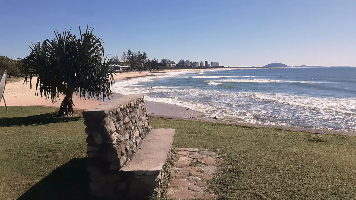 Surfers off Alexandra Headland with Mount Coolum up the coast