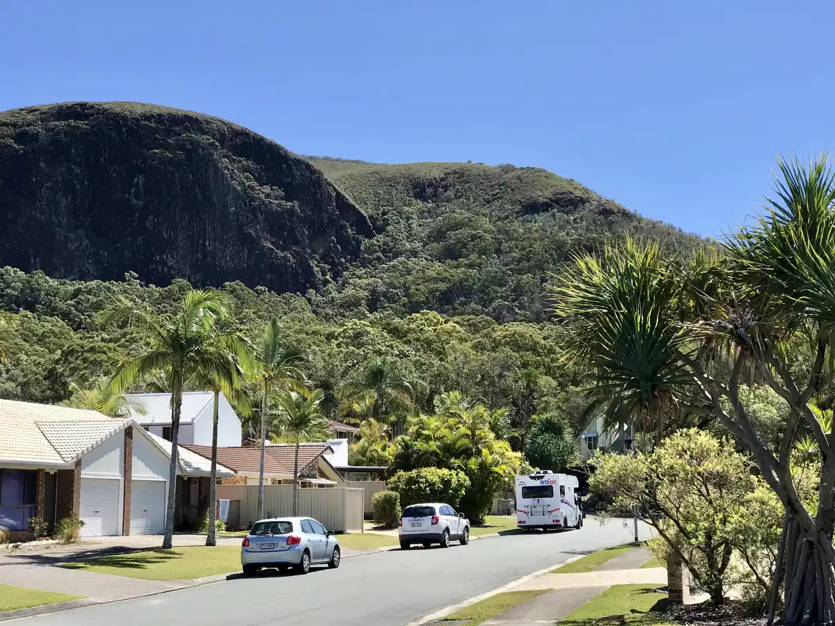 Mount Coolum's dome rising behind suburban streets