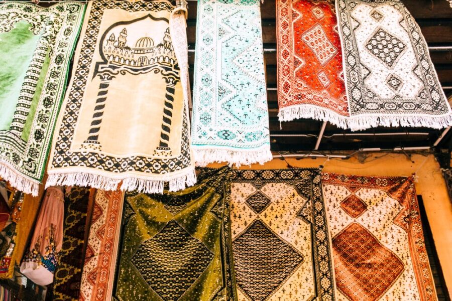 Patterned rugs and prayer mats hanging for display