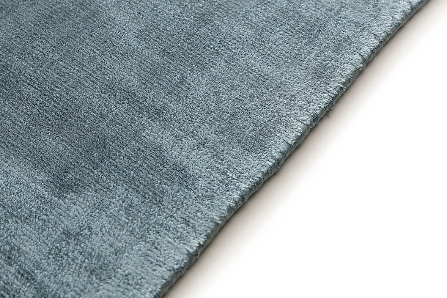 Close-up of a grey-blue viscose rug edge