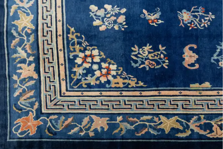 Close-up of a navy Chinese rug corner with a floral border