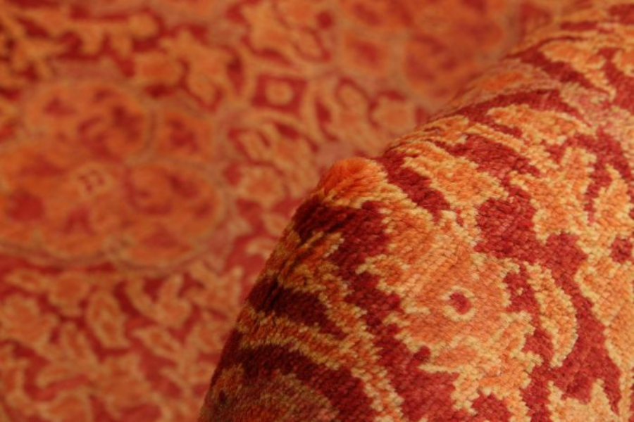Close-up of a red and gold ornate rug fold