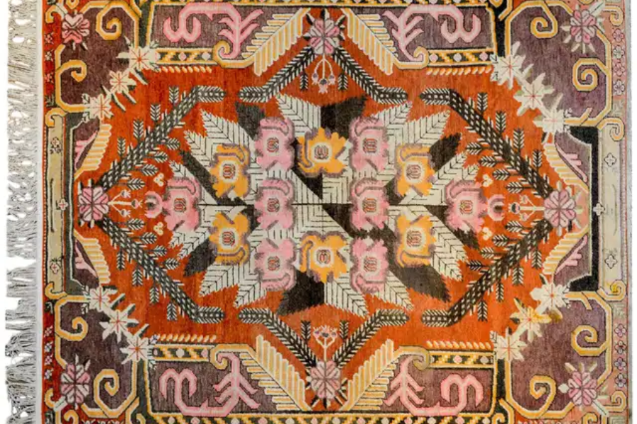 Orange Central Asian rug with a pink and gold geometric medallion