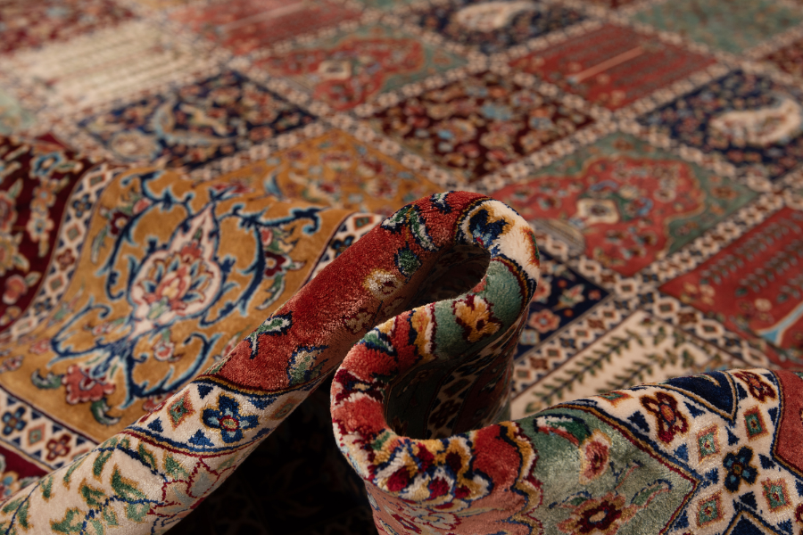 Close-up of a rolled patchwork-pattern silk rug corner